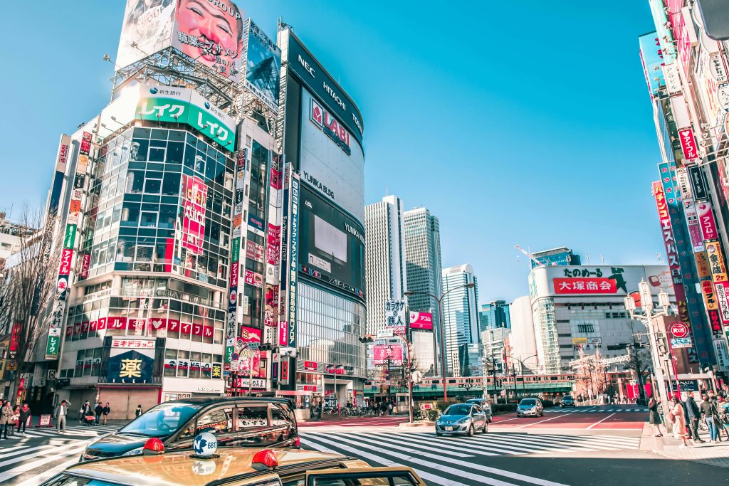 A bustling Tokyo intersection surrounded by skyscrapers and bright advertisements.