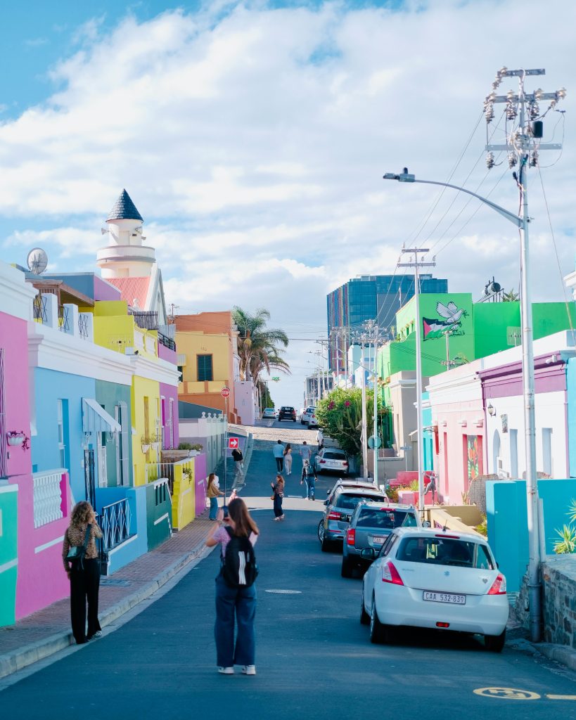 Vibrant street in Bo-Kaap, Cape Town, with colorful houses and lively atmosphere.